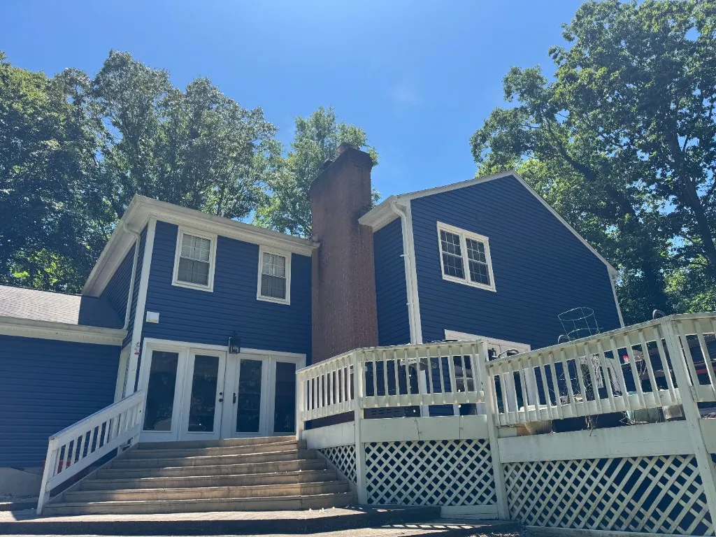 Blue home with replacement siding, white trim, and deck